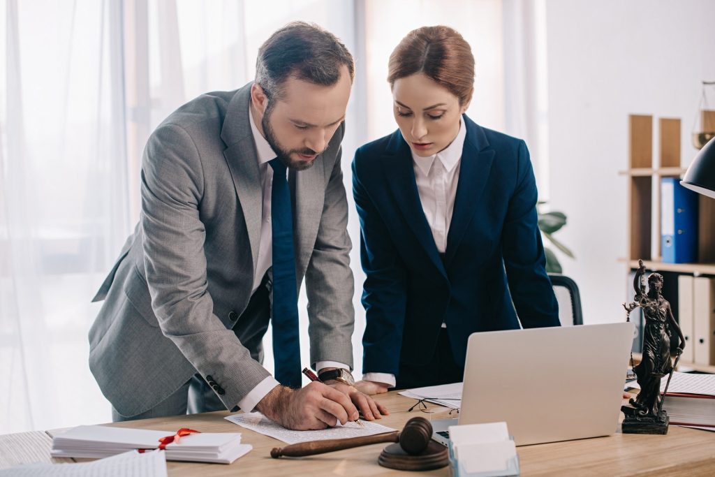 Professional legal advice session with solicitors reviewing case documents and contract agreements in a law firm office.